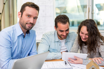 Young attractive people meeting real estate agent at the office