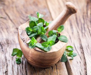 Fresh mint, wooden mortar and pestle.
