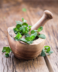 Fresh mint, wooden mortar and pestle.
