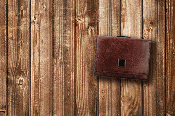 Brown leather wallet on wooden background