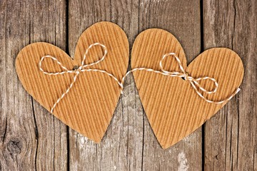 Two rustic heart shaped cardboard gift tags against a vintage wood background