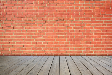 Red brick wall on wooden floor.