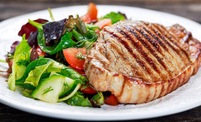Grilled pork meat and vegetables on plate