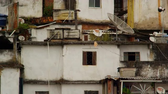 Static shot of a favela facade with a kite being flown