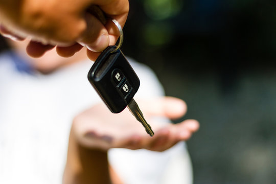 Young adult girl receives the key of her new car