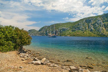 Fototapeta premium view of tourist boat in sea from island rocky beach