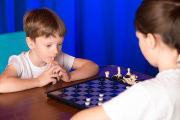 Children boy and girl playing a board game called Checkers