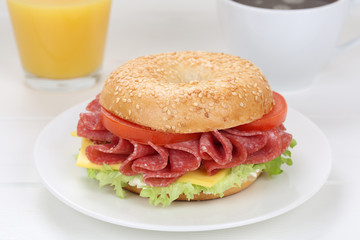 Bagel Brötchen zum Frühstück mit Salami Schinken, Kaffee und