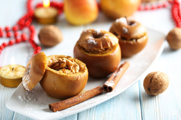 Baked apples on plate on blue wooden table