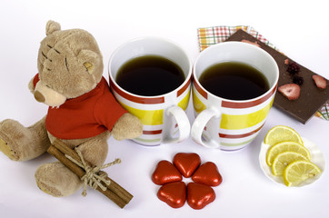 Teddy bear, two cups tea, chocolate hearts, lemon and cinnamon.
