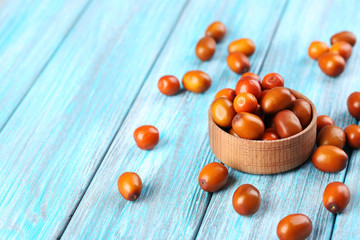 Ripe jujubes on blue wooden table, close up