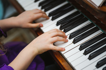 kids hands on a white piano key