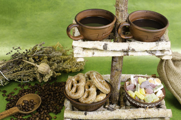 Two cups of coffee, coffee beans, cookies and fruit candy on a s