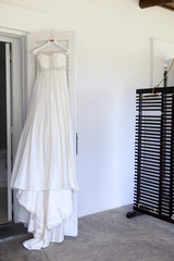wedding dress hanging up by the door