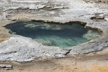 Aqua water of thermal pool in limestone rock of Yellowstone Park, Wyoming.