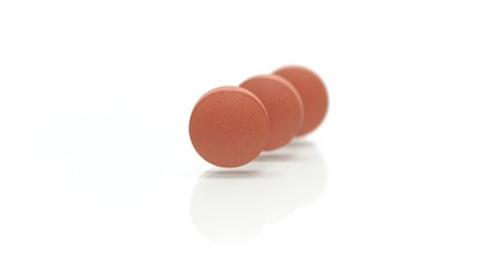 Three brown pills standing on end.