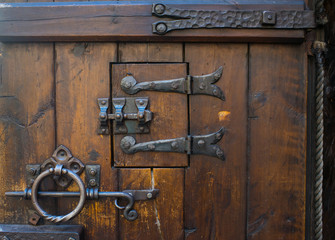 Medieval door lock. Oak door with iron lock.