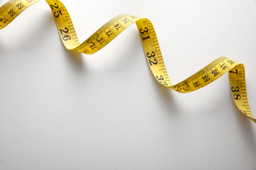 Yellow tape measure in meters and inches spiral and diagonal