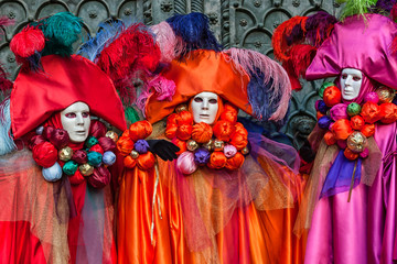 Masks in beautiful multicolored costumes at Carnival in Venice