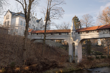 Ladek Zdroj - covered bridge over river in city park.