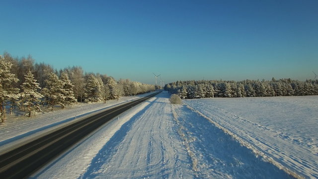aerial view at the winter road with windmills