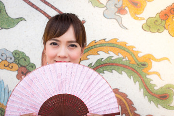 Beautiful Asian woman wearing traditional Cheongsam on chinese pattern traditional background