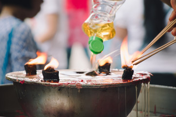 Burning Joss stick and oil palm candle at chinese shrine for making merit in chinese new year festival. Pray for New Year, Lighting incense to Buddha.