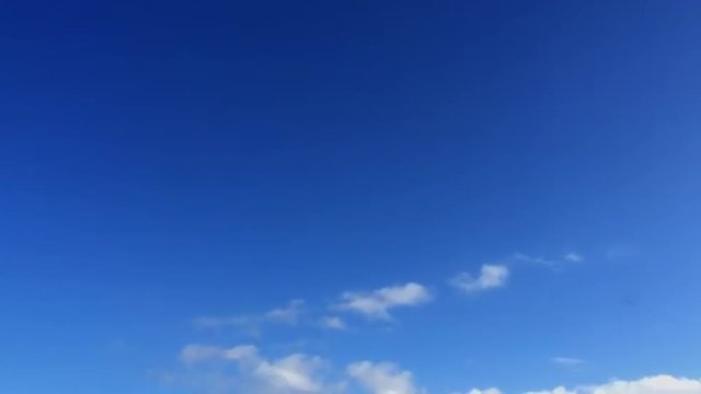 Clouds passing across blue sky in time lapse