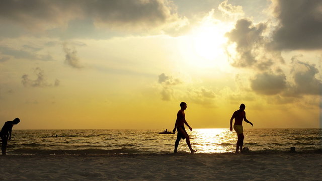 Silhouettes of Brazilians playing beach football 