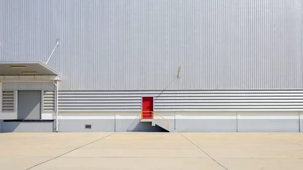 Papier Peint photo Bâtiment industriel the sheet metal factory wall with the red door entrance
