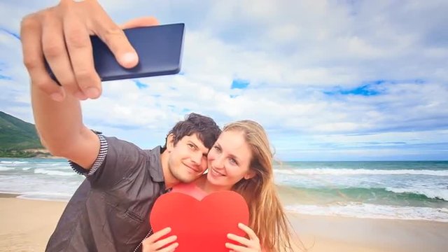 Guy Blond Girl Make Selfie with Heart Kiss on Beach Wave Surf