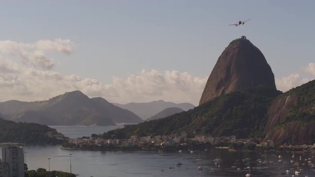Static footage of an airplane flying over Sugarloaf Mountain - Rio de Janeiro, Brazil.