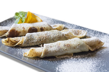 Delicious pancakes with powdered sugar on a white background