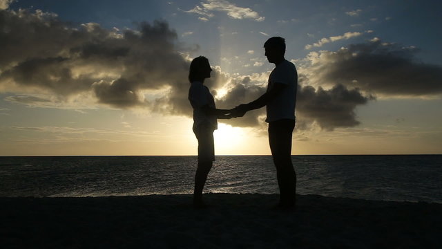 sunset silhouette of couple on the beach