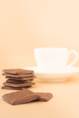 White mug of hot coffee and chocolate pieces