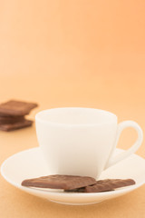 White mug of hot coffee and chocolate pieces