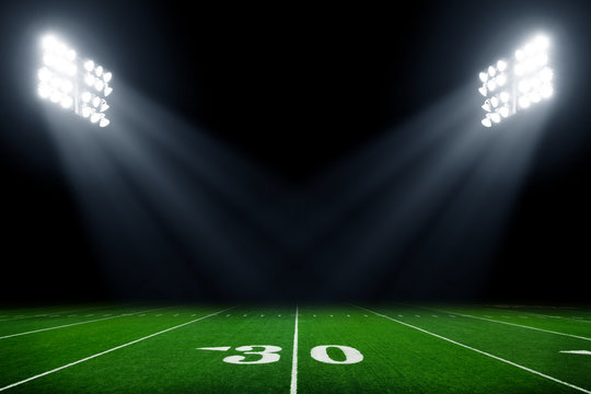 Football field illuminated by stadium lights