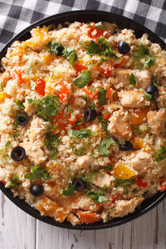 couscous with chicken, olives and vegetables closeup. vertical top view
