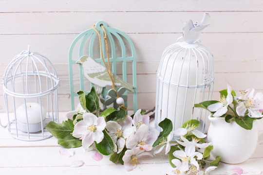 Apple blossom and candles in decorative bird cages