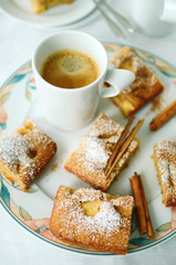 Apple cinnamon cake cut in pieces with a cup of coffee