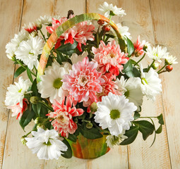 image of beautiful flowers in a basket on a wooden table