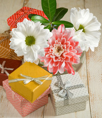 images of flowers and gift boxes on a wooden table close-up