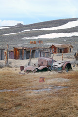 Bodie ghost town car and houses with snow mountain