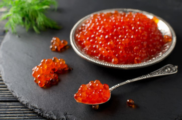 Red salmon caviar on black background