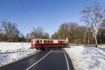 train of the Selketal line crosses a street in winter landscape