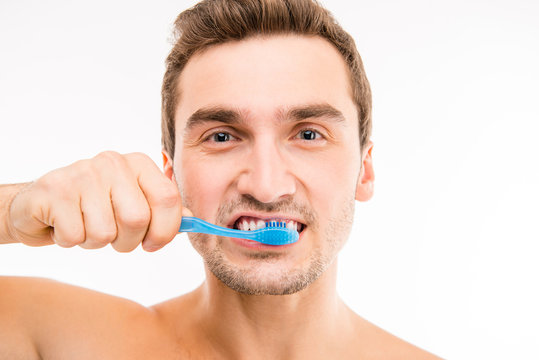 Close up photo of attractive man brushing his teeth