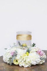 Obraz na płótnie Canvas White candle among flowers. Wedding table centerpiece