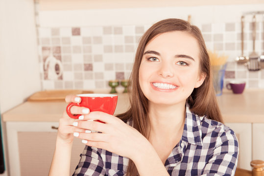 Close-up portrait of  girl holding a cup of tea in the kitchen