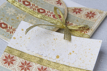paper bright invitation card with an ornament decorated with a gold tape