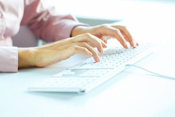 Woman office worker typing on the keyboard